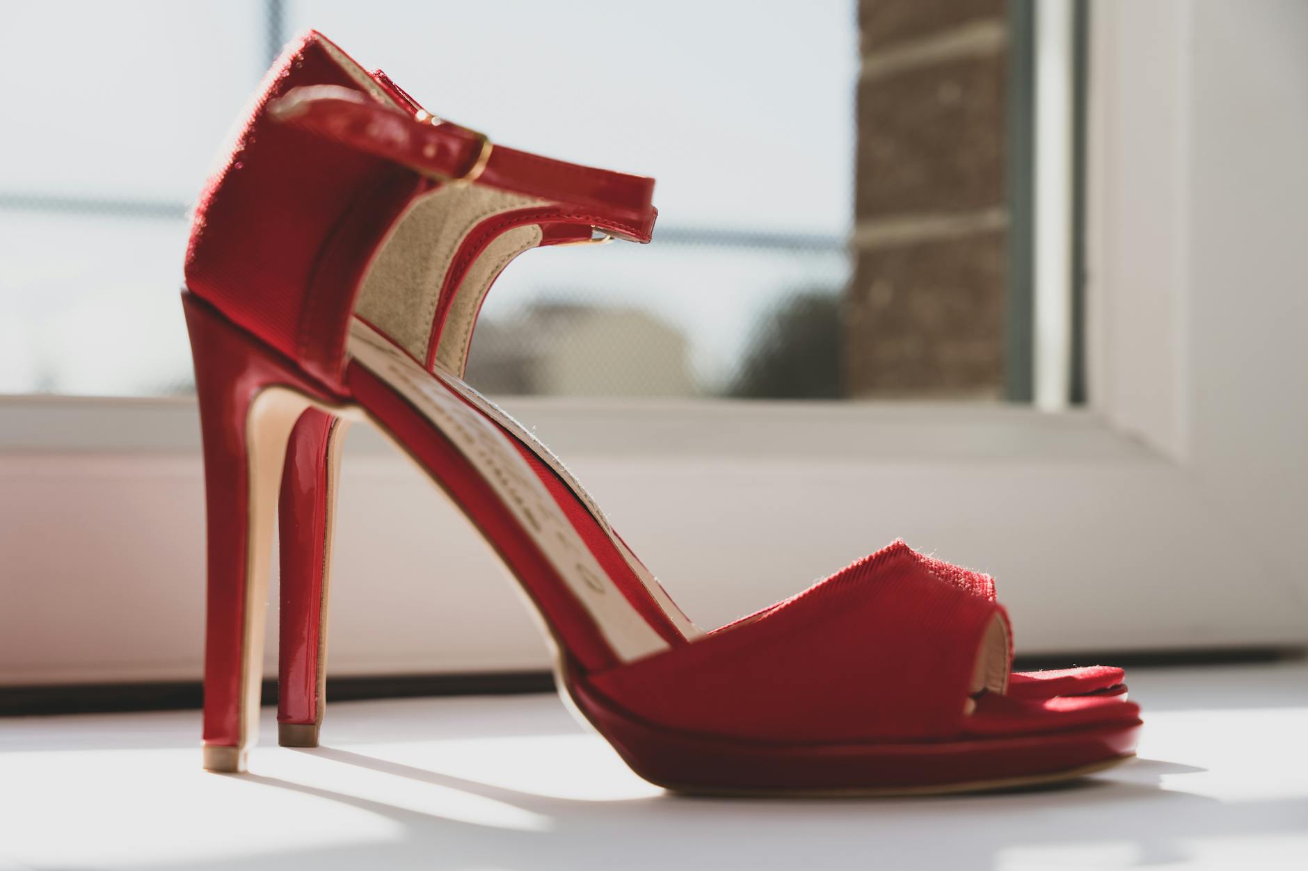 A stylish photo of red high heels by a window capturing elegance and fashion essence. [pexels]